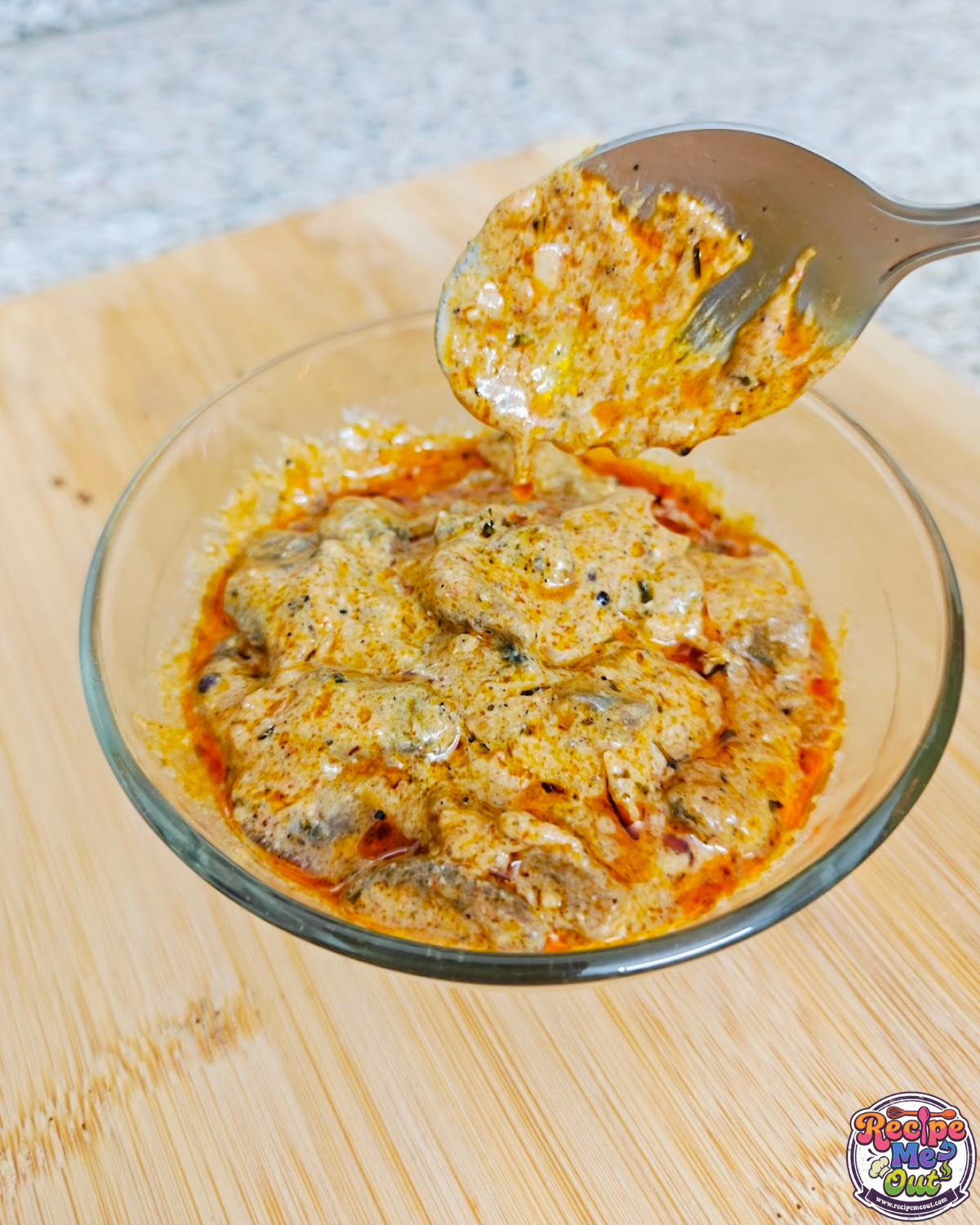 Closeup shot of Creamy Mushrooms in Tomato Alfredo Sauce with a steel spoon