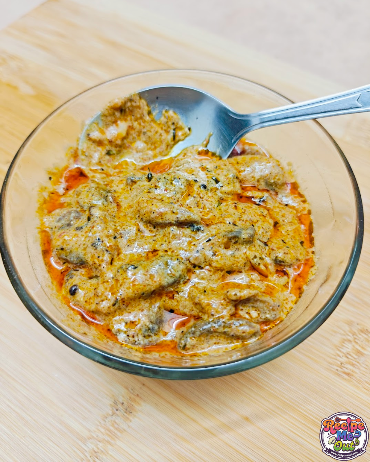 Closeup shot of Creamy Mushrooms in Tomato Alfredo Sauce with a steel spoon