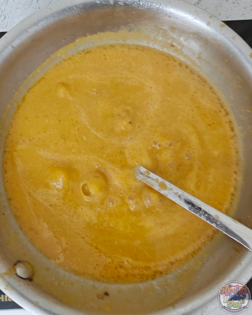 The pumpkin pasta sauce simmering in the pan, becoming smooth and creamy.