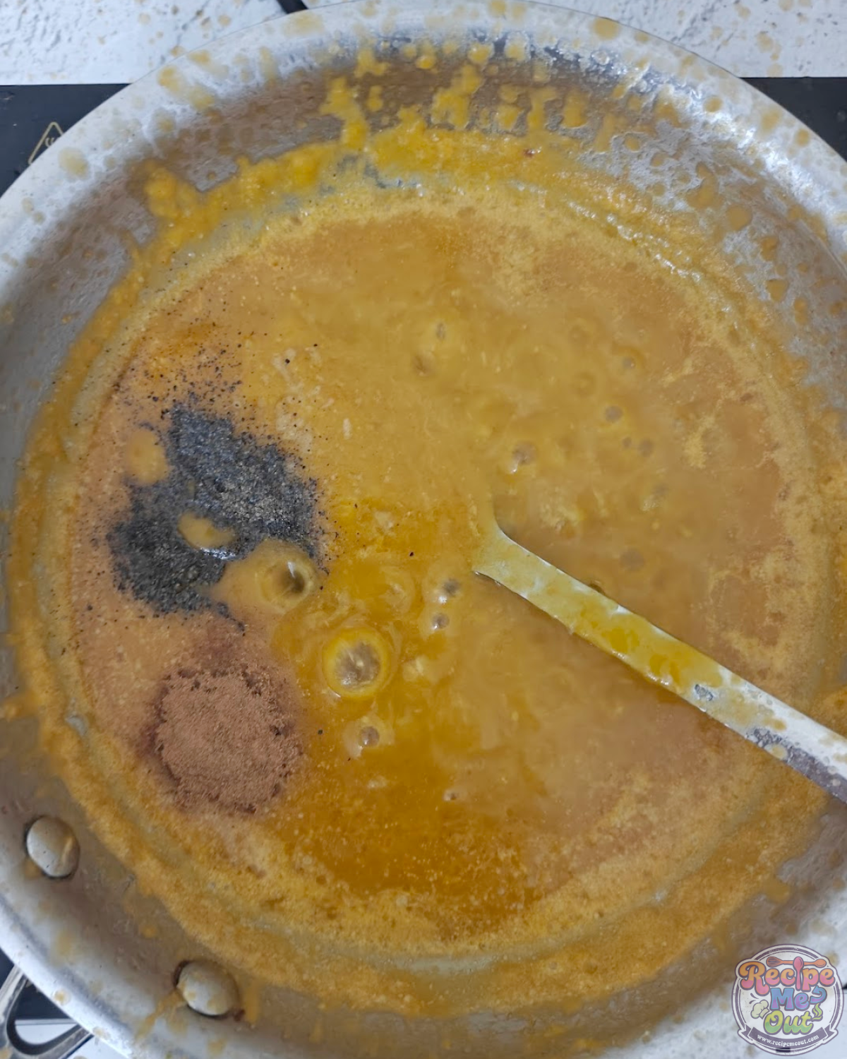 Black pepper and cinnamon powder added to the pumpkin sauce while it simmers in the pan.