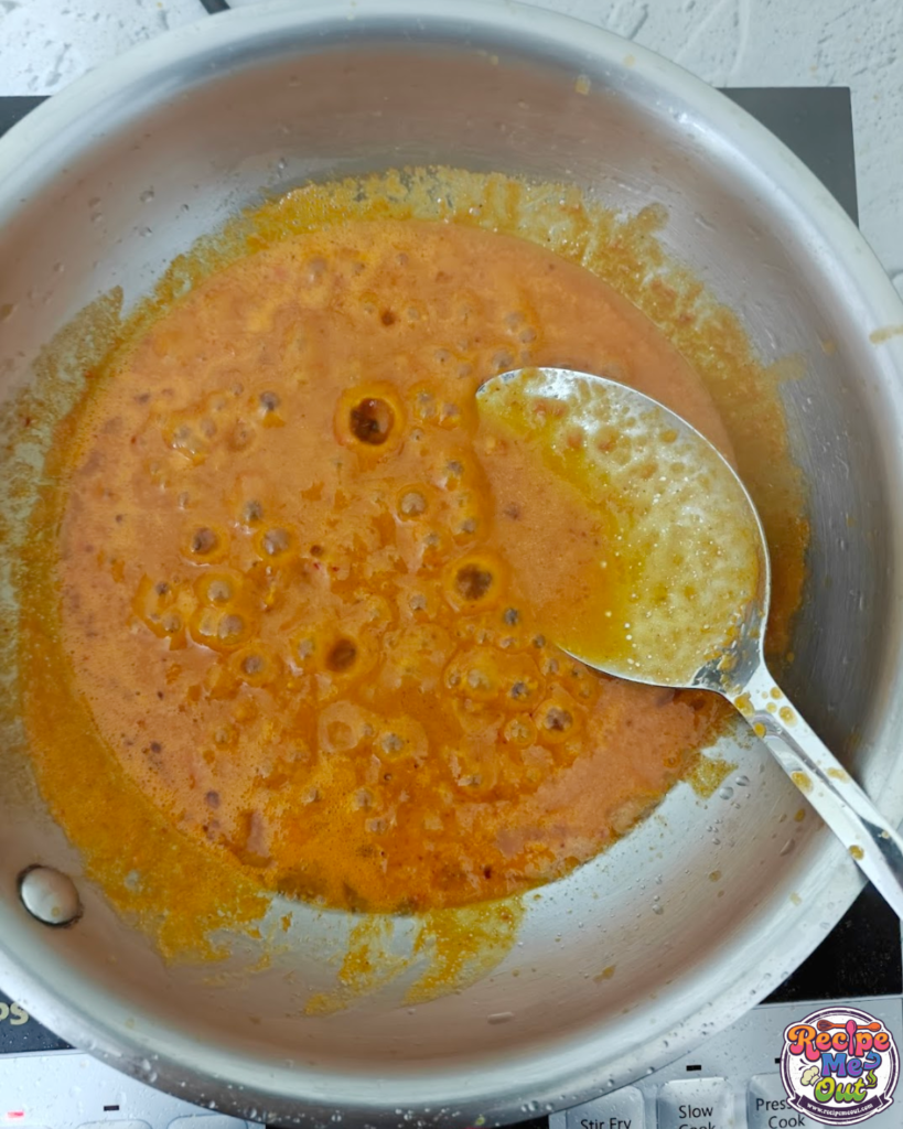 Tomato mustard sauce simmering in a pan until smooth and rich