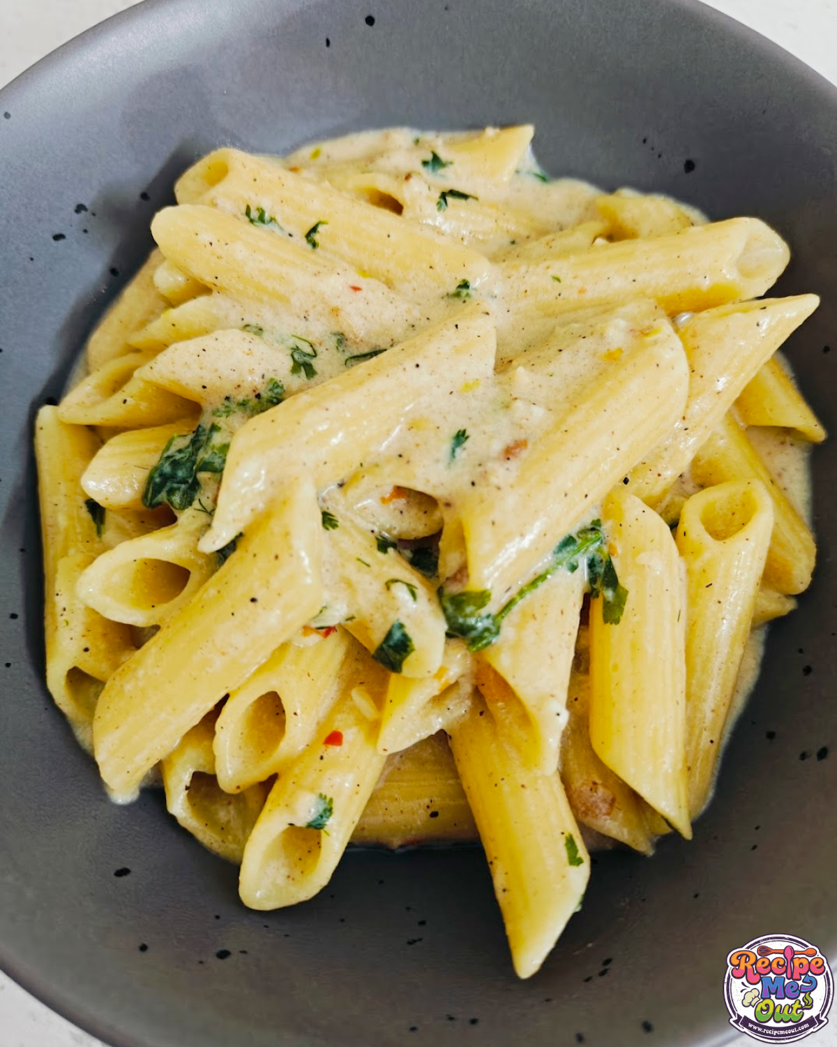 Close-up of butter garlic cilantro penne served in a gray bowl.