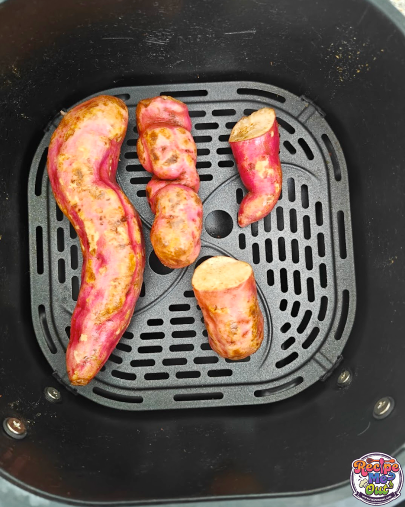 Sweet potatoes arranged inside an air fryer basket, ready to cook at 180°C.