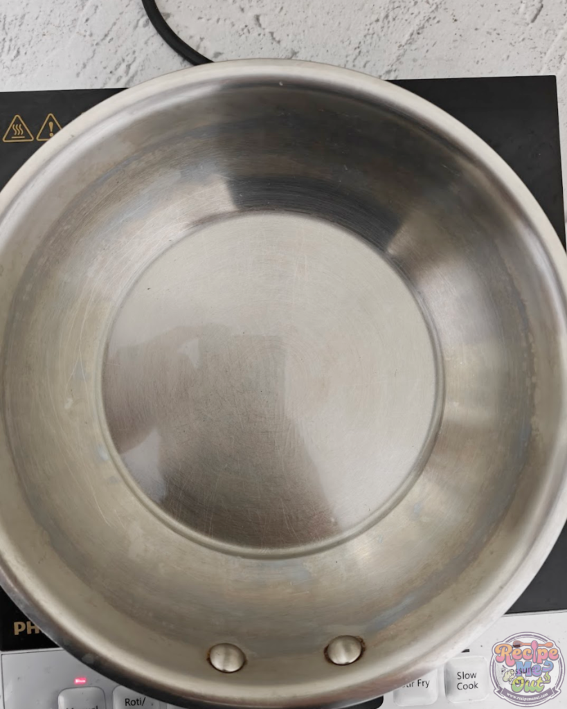 An empty pan placed on the stove with oil heating to start cooking the pumpkin pasta sauce.