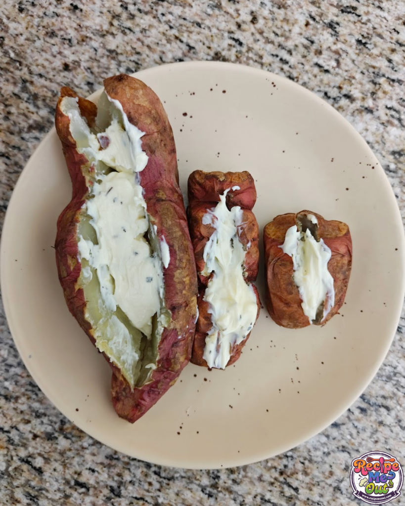 A cooked sweet potato carefully sliced lengthwise down the middle with a pocket filled with cheese. 