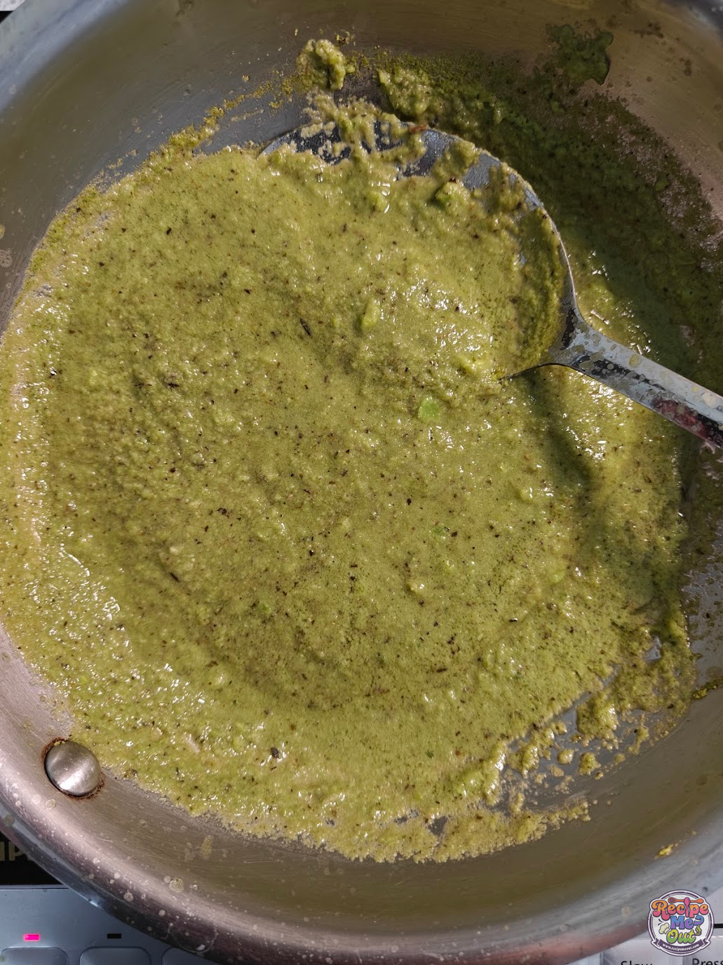 Thickening green peas sauce being stirred in pan while cooking