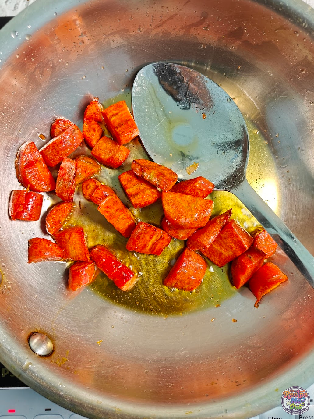 Chopped carrots sautéing in oil in a pan until partially cooked to form the base for carrot pasta sauce.