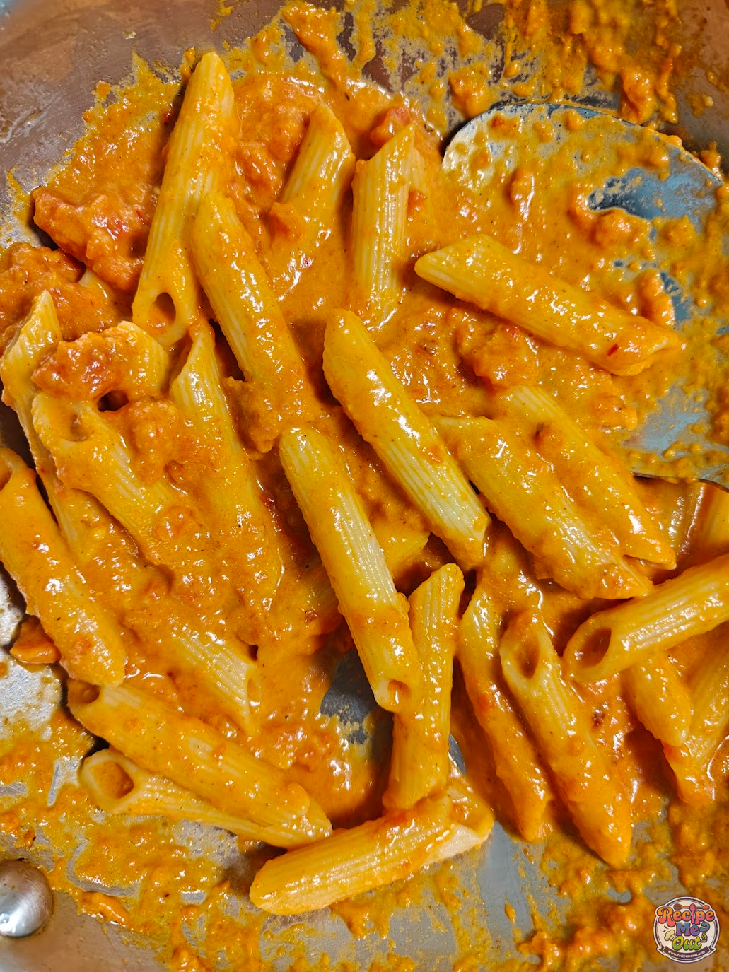 Cooked penne pasta, evenly coated with the sauce