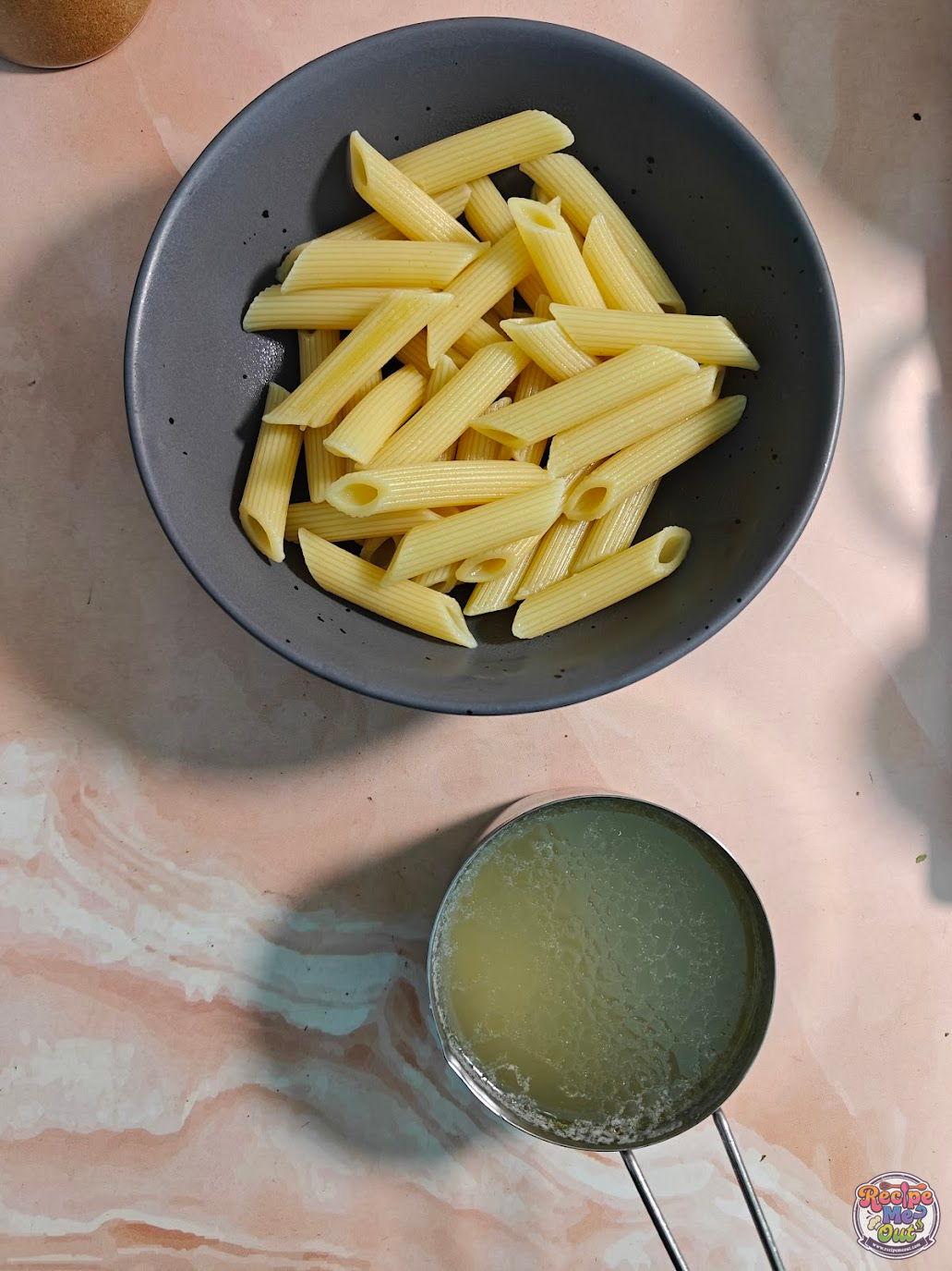 Cooked penne pasta with reserved pasta water prepared for making Green Peas Pasta