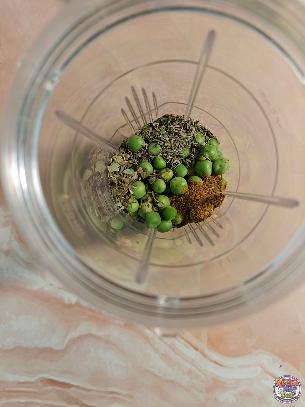 Herbs and spices added to green peas in blender for making Green Peas Pasta paste