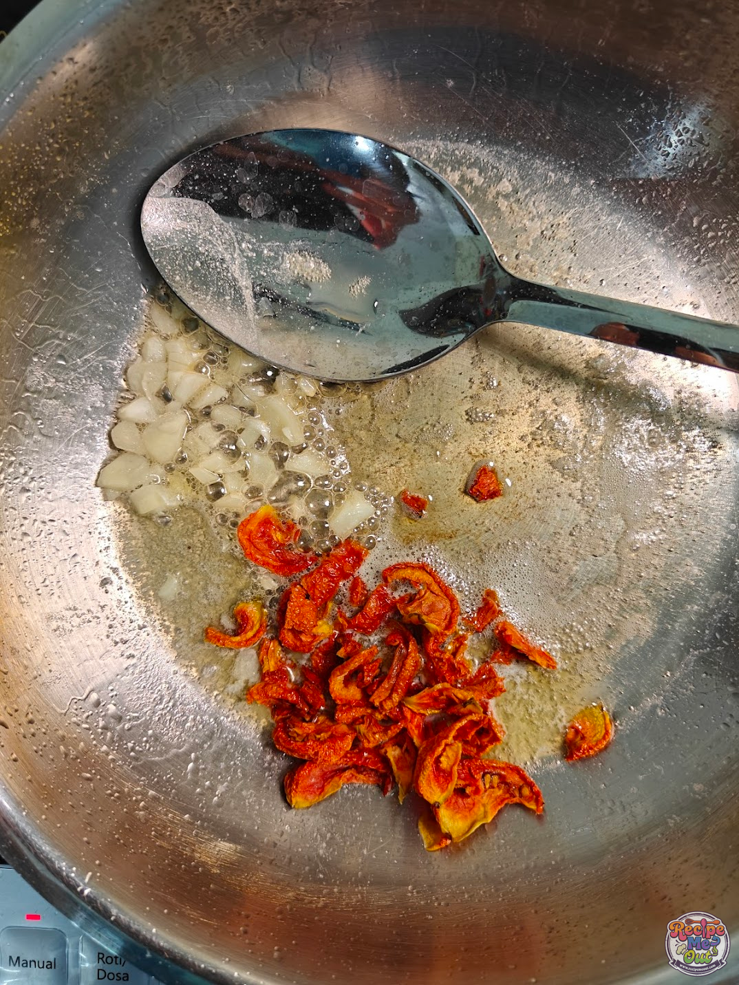 Sun-dried tomatoes added to garlic butter in pan
