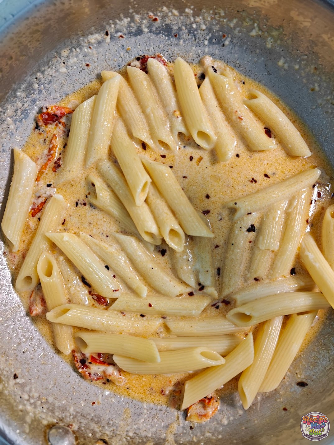 Boiled penne pasta added into the creamy sauce