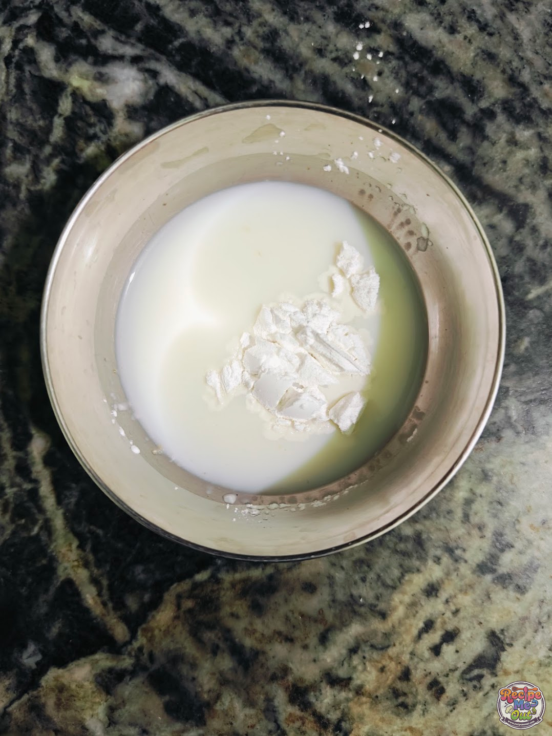 Corn starch mixed with milk in a small bowl to make a smooth slurry for thickening the pudding.