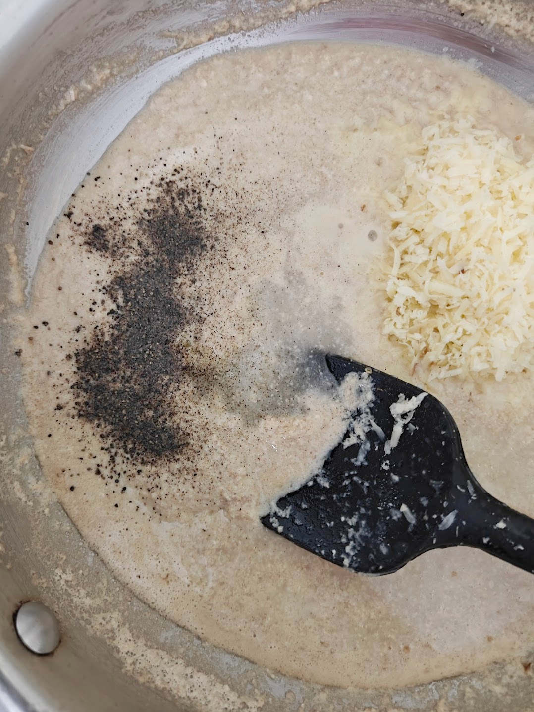 crushed black pepper being added to the paste along with grated parmesan