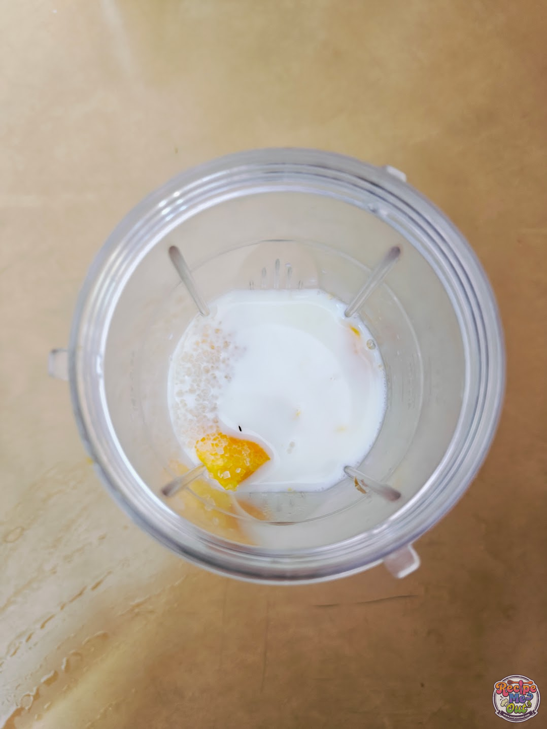 mango chunks, milk and sugar in a blender before blending it.