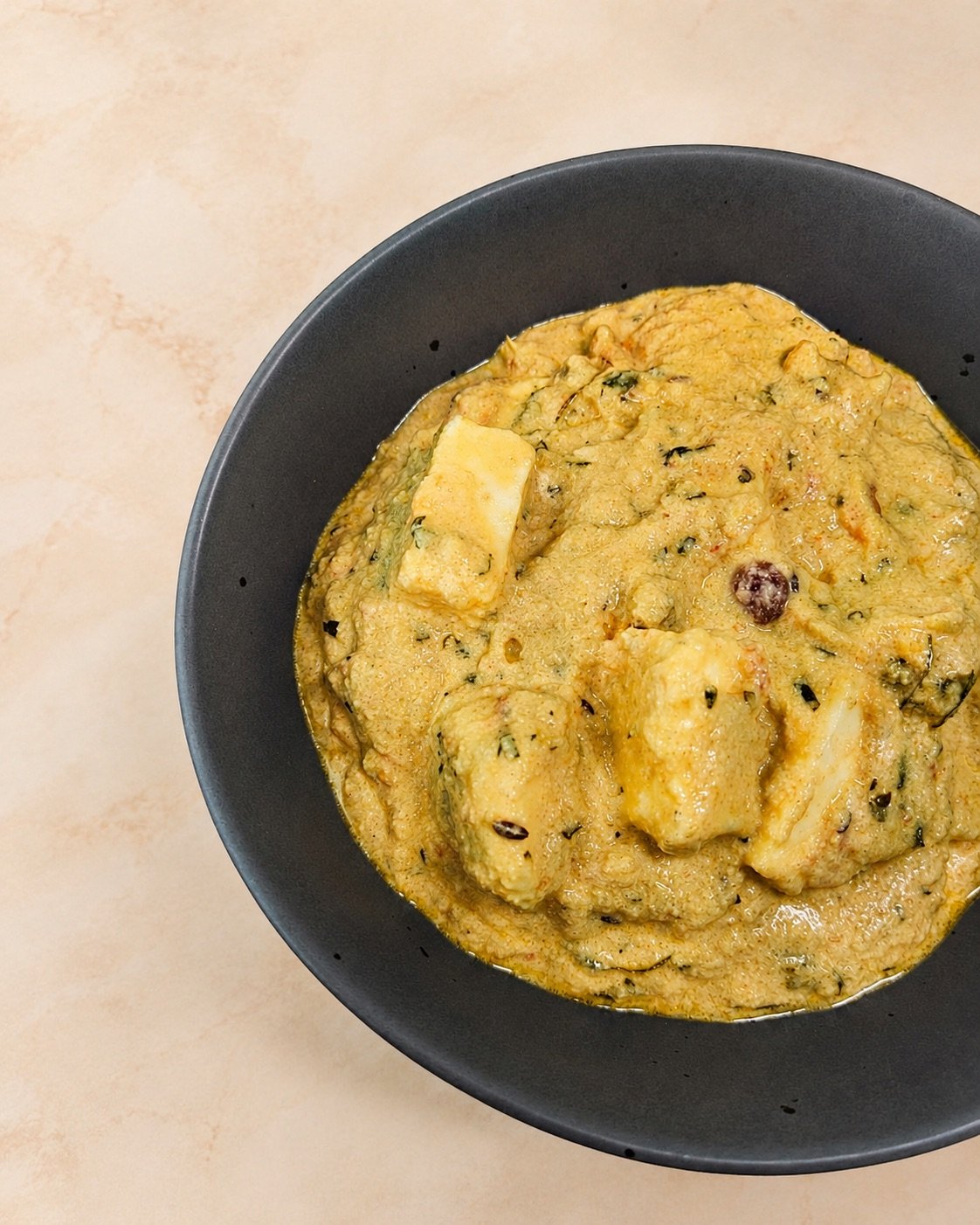 Paneer cubes in creamy white sauce served in a bowl.