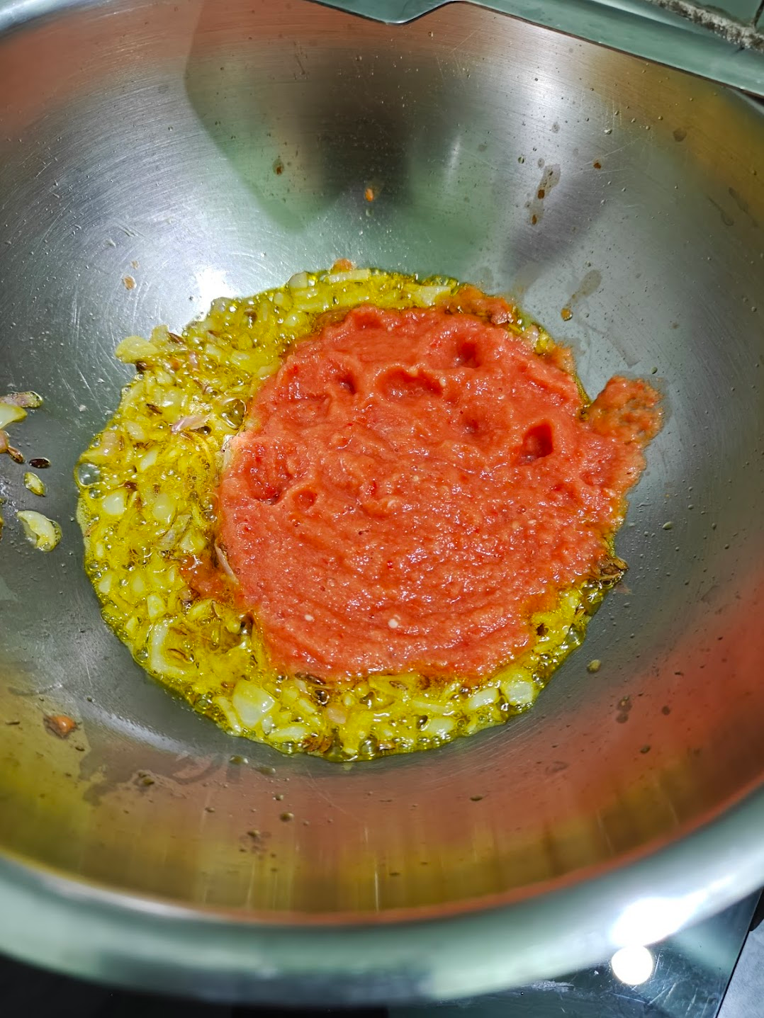 Tomato puree added to sautéed onions and spices for paneer masala.