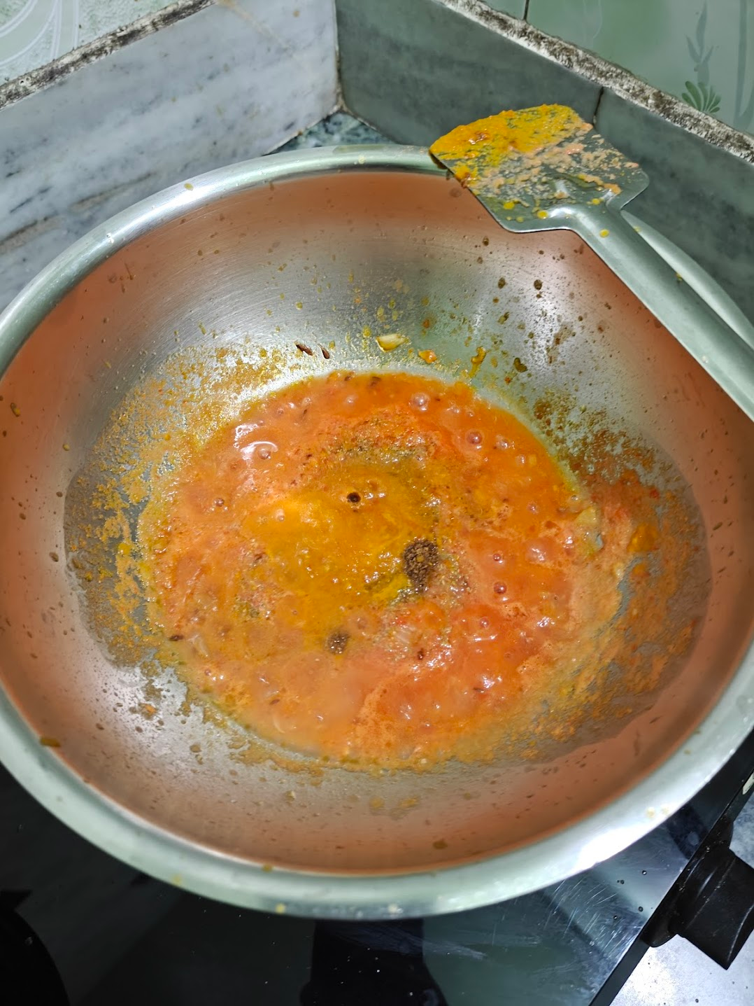 Fresh tomato puree cooking with onion masala and spices.