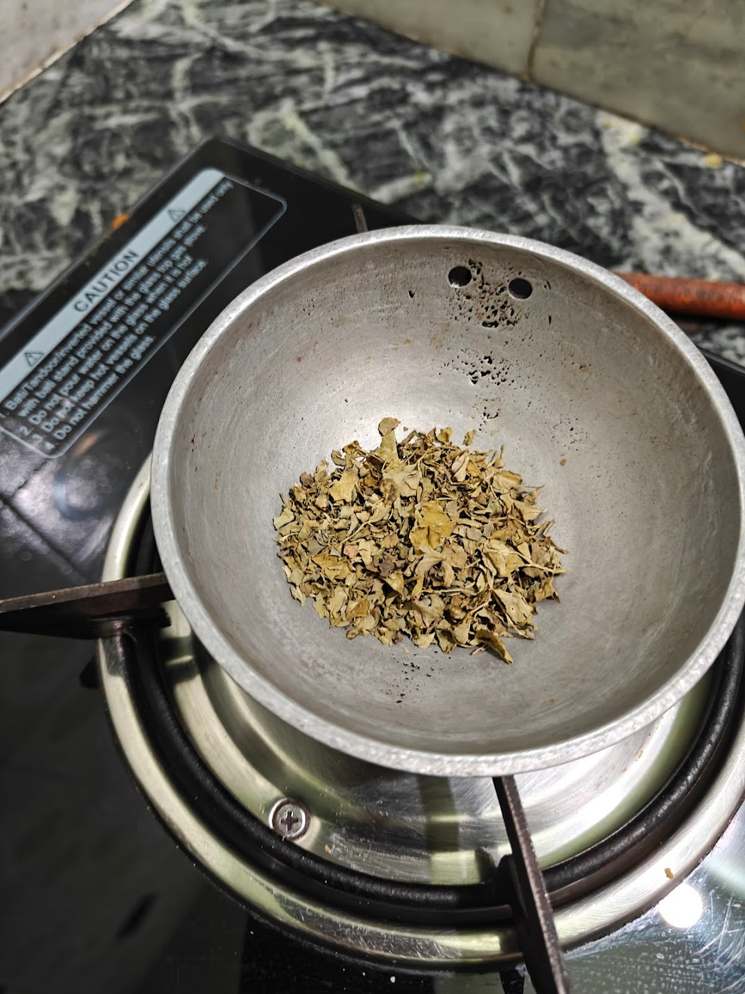 Dried kasuri methi warming in a small pan before adding to paneer masala.