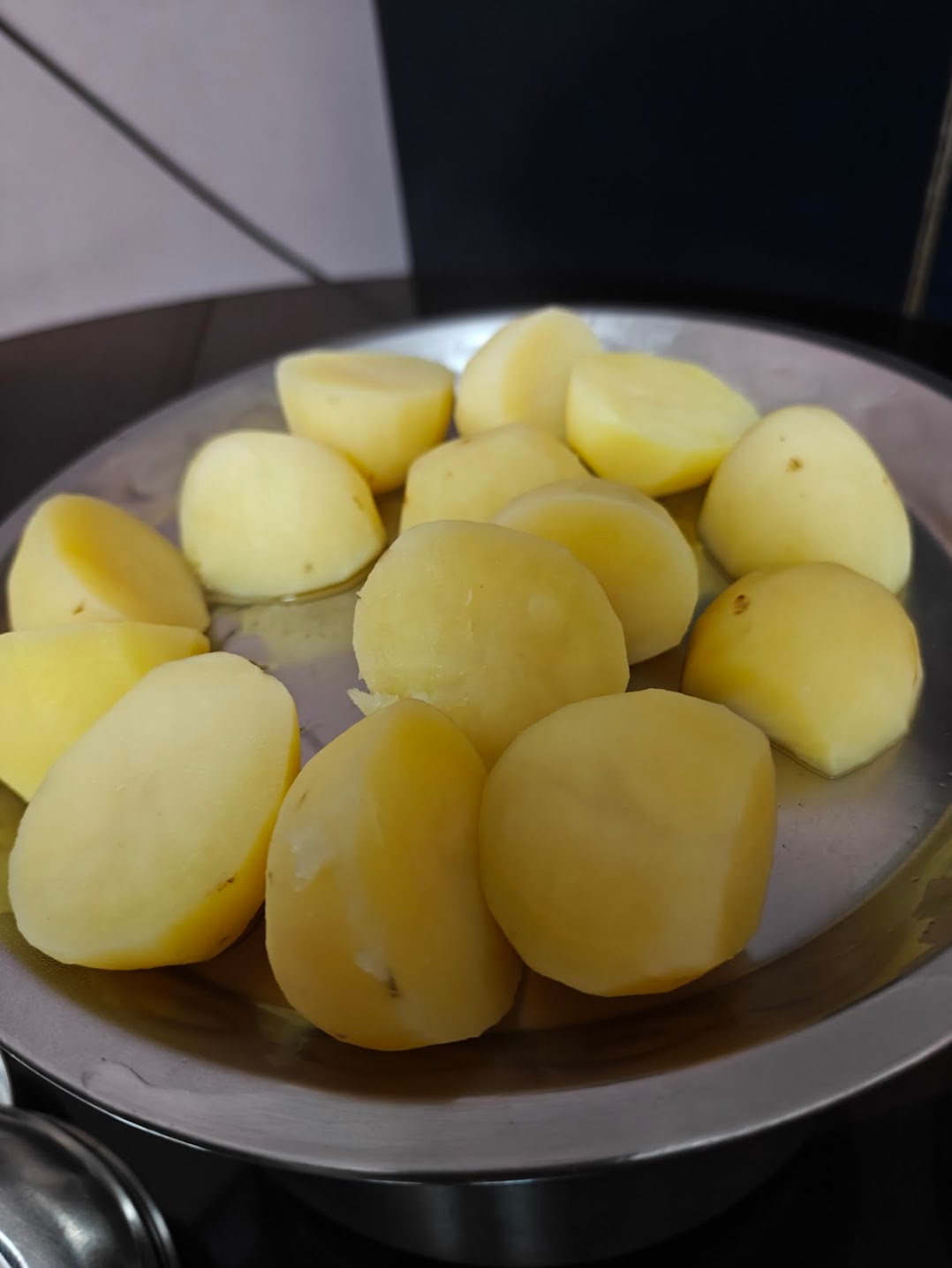 Boiled half-cut potatoes being kept aside