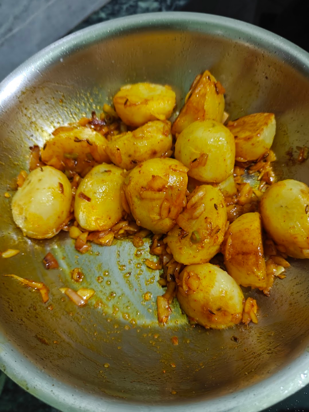 Golden potatoes tossed with onion and all the remaining spices (except the achari spice mix which will be added later)