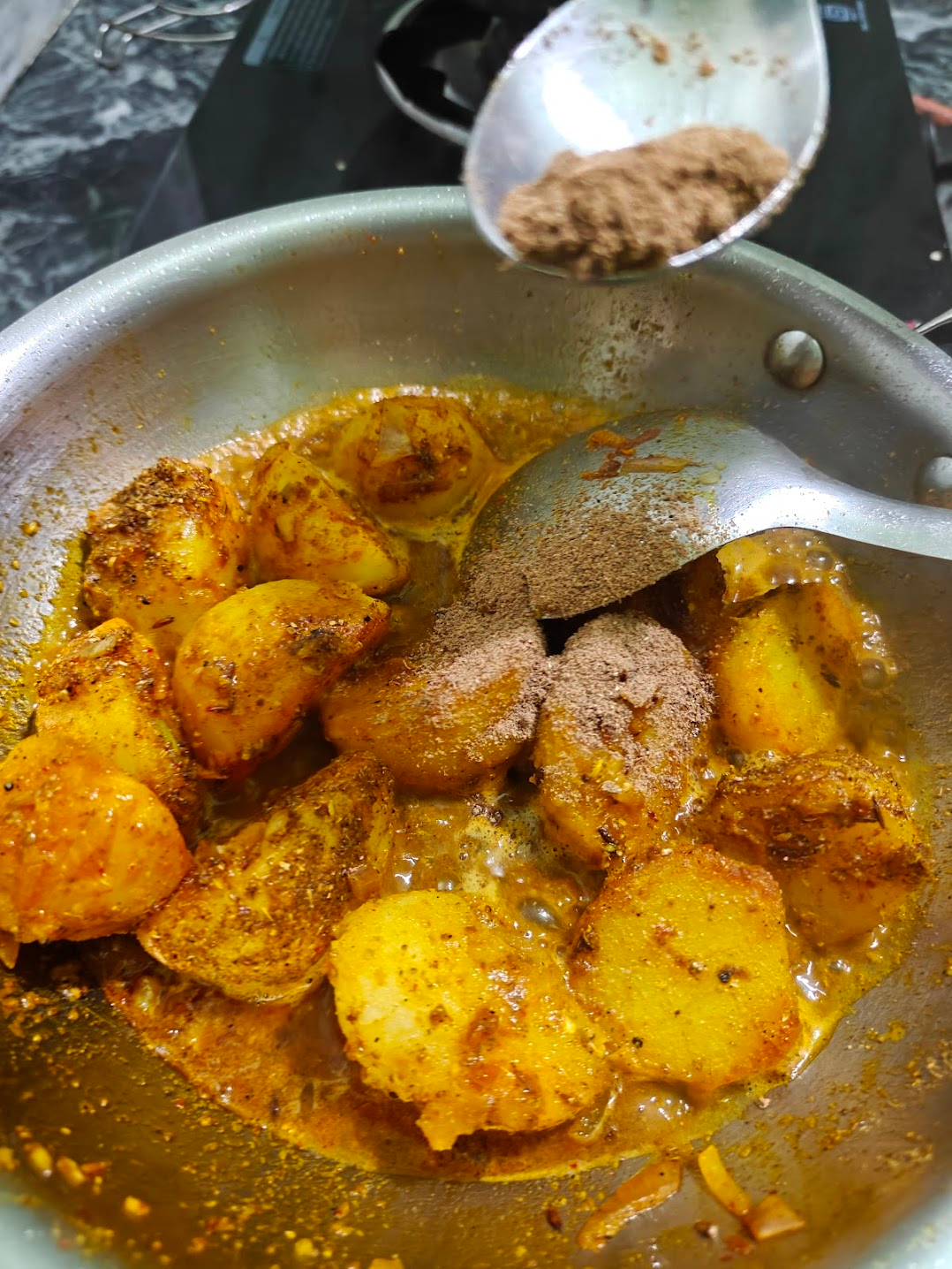 Roasted achari spice mix added to the potato curry