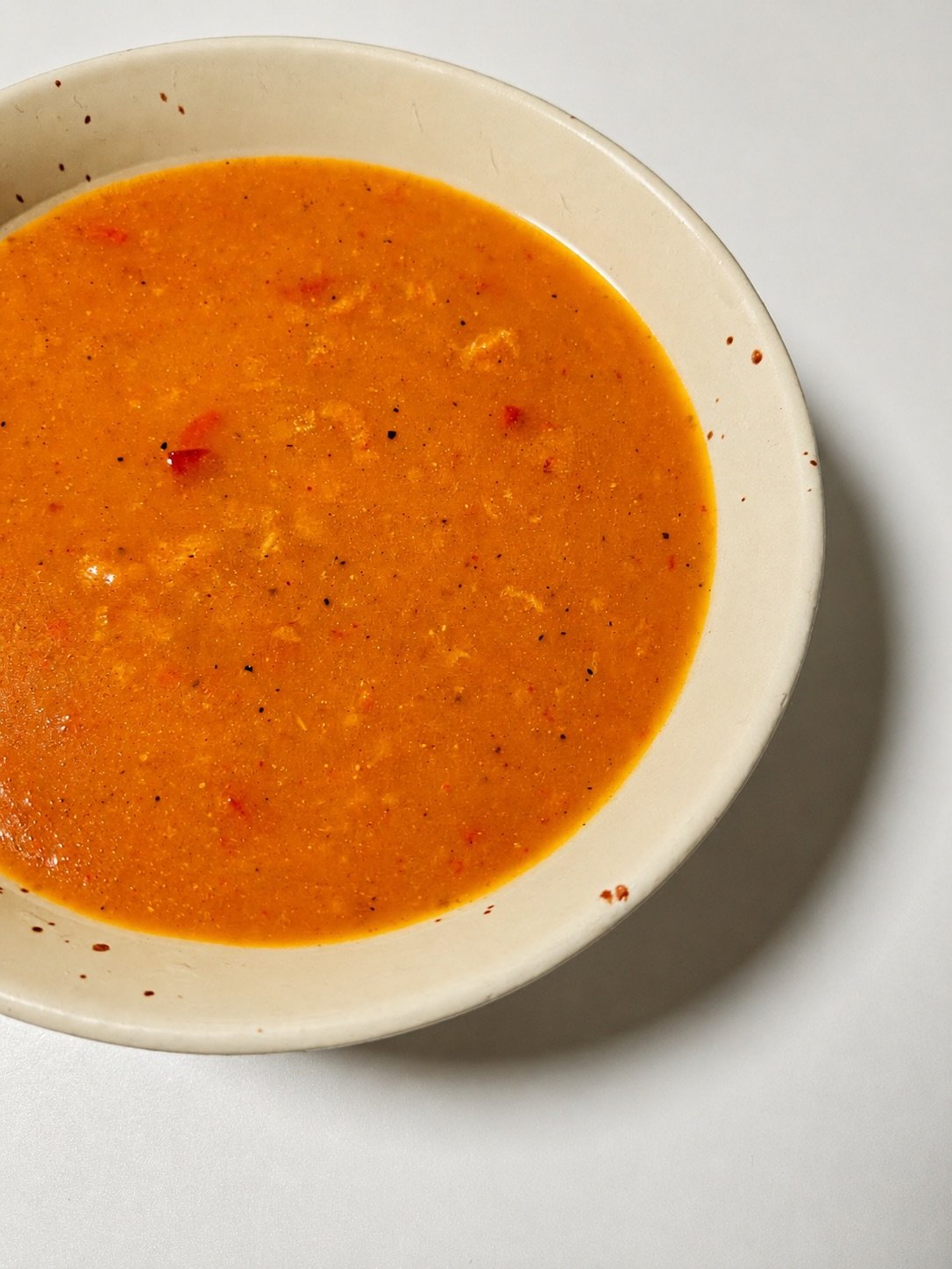 Finished tangy mango soup served in a cream bowl