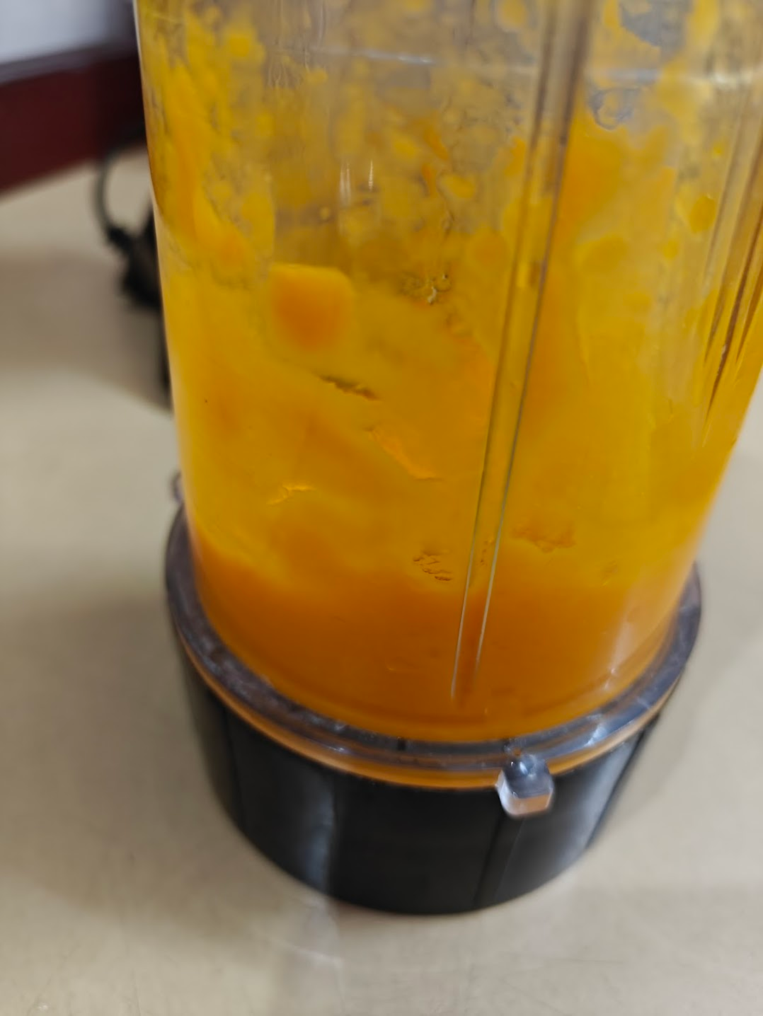 Mango pieces being blended into a smooth puree