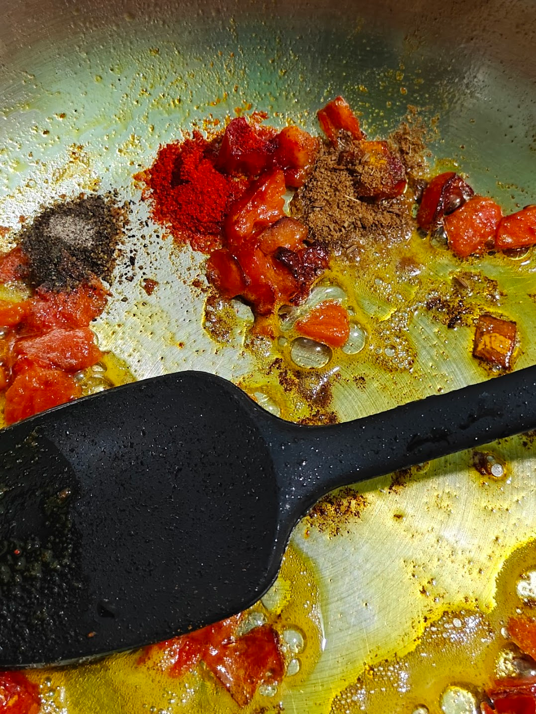 Roasted cumin, coriander, and red chilli powder added to sautéed tomatoes