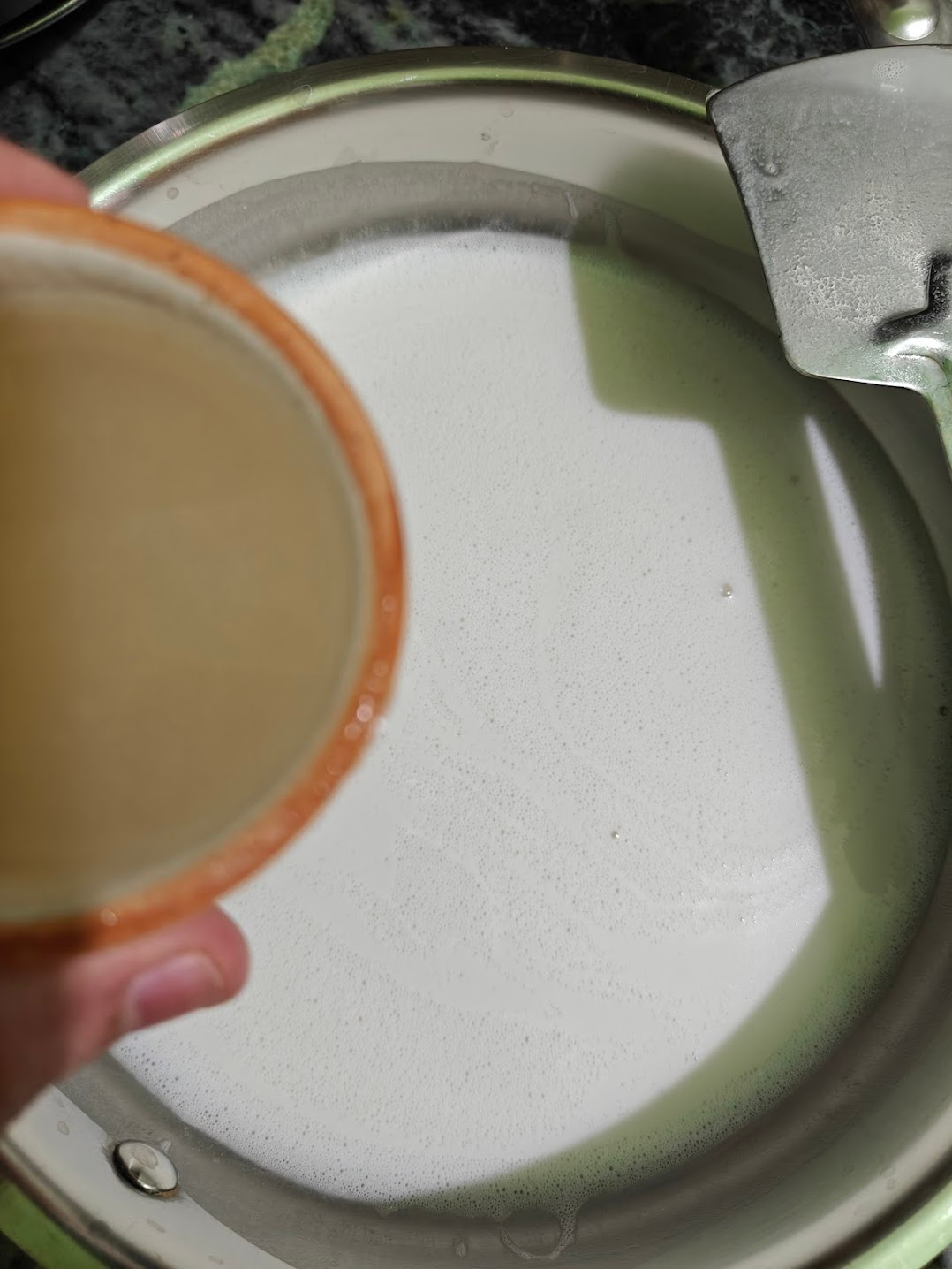 Agar agar mixture being poured into warm coconut milk